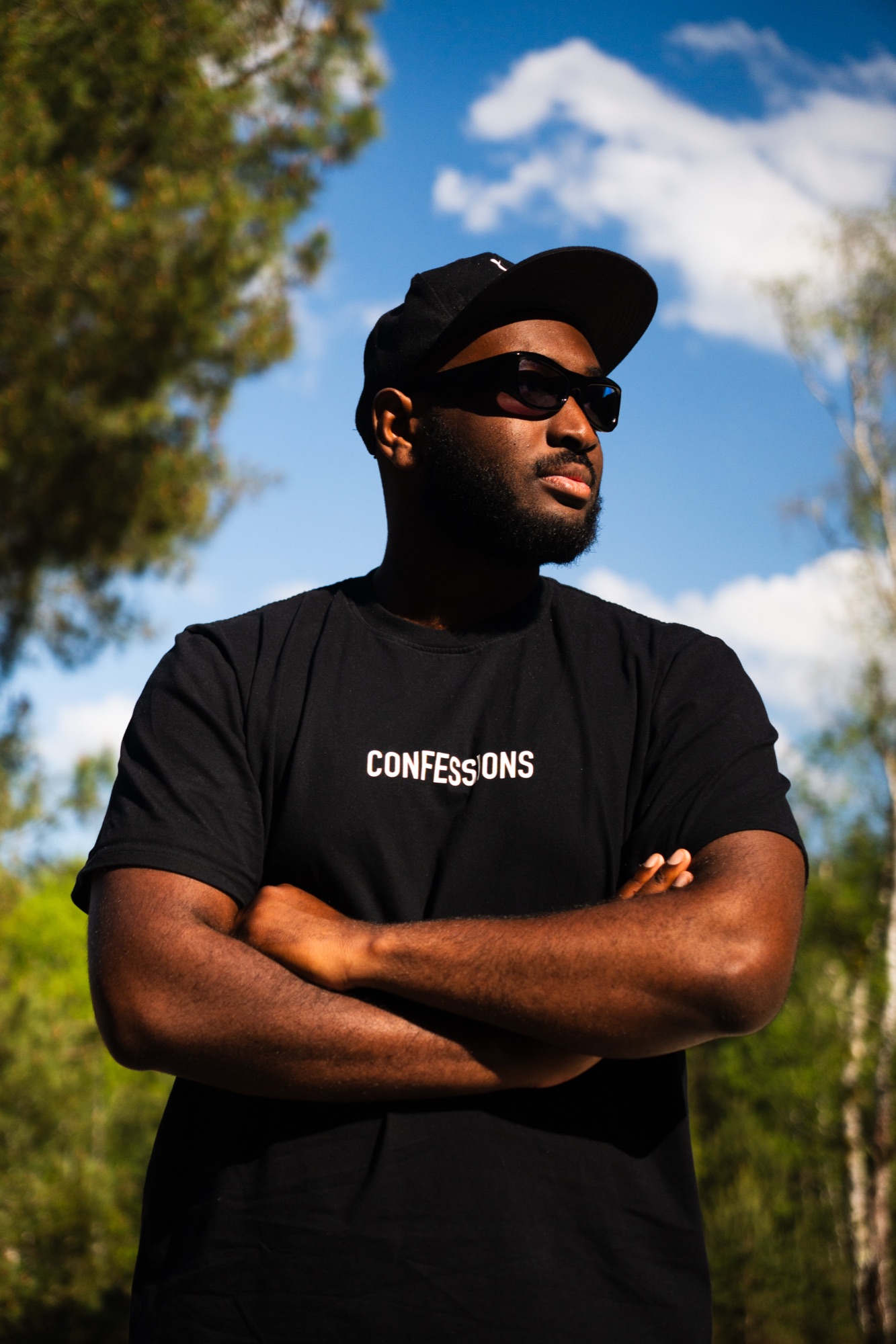 Portrait solo d'un modèle portant le t-shirt Confessions Paris, ciel en arrière-plan