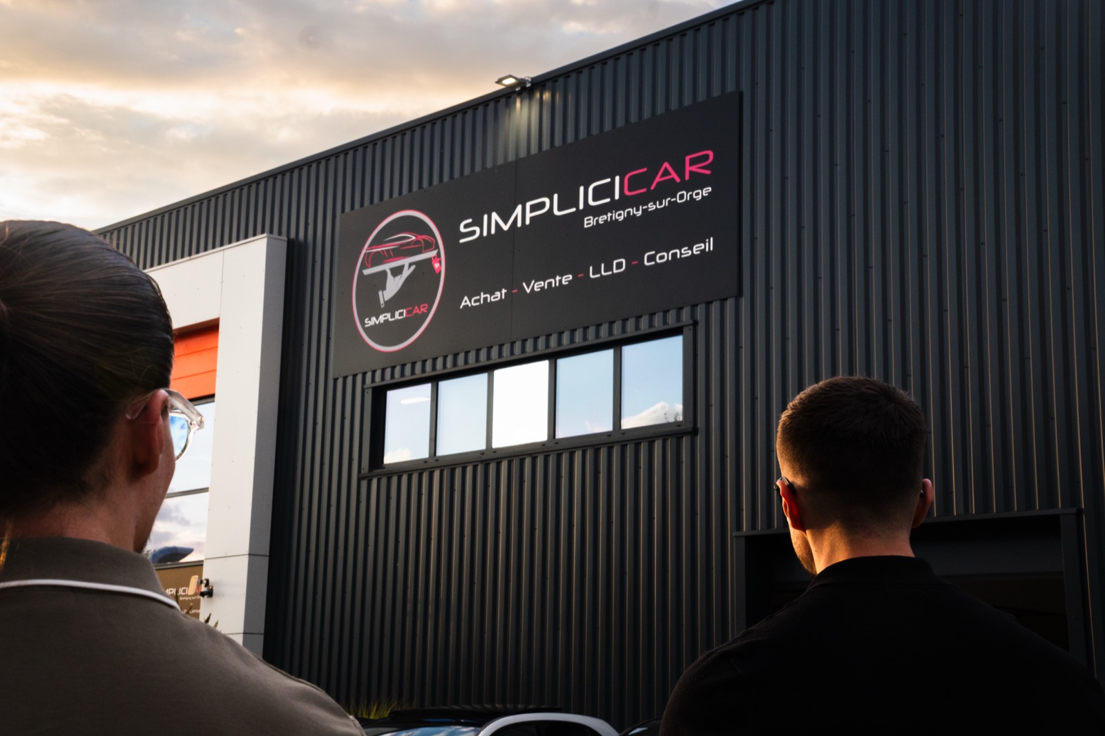Clients devant l'enseigne du concessionnaire Simplicicar Brétigny-sur-Orge